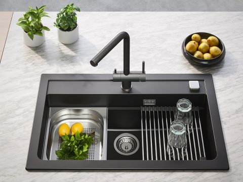 Fregadero de granito negro con grifo de cocina negro y accesorios integrados en el fregadero: escurridor con fruta y soporte para escurrir vasos