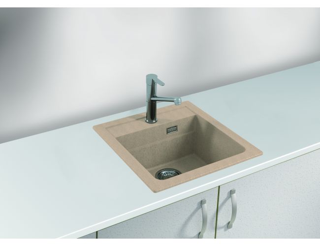 Fregadero de granito beige con grifo de cocina cromado sobre una superficie de trabajo blanca