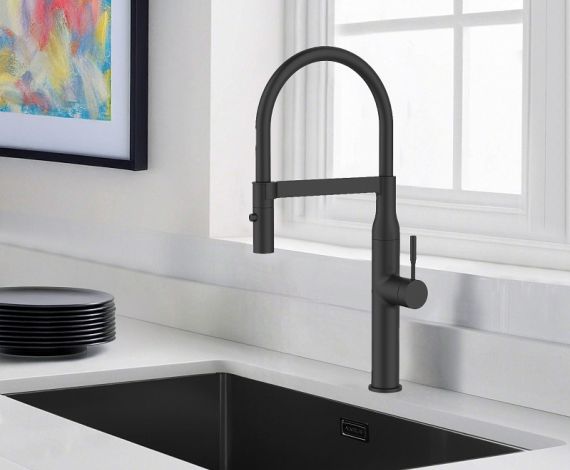 Grifo de cocina blanco y fregadero de acero inoxidable en una cocina blanca con un fondo verde o naturaleza visible a través de la ventana