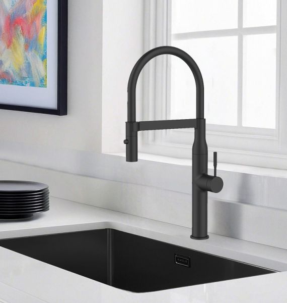 Grifo de cocina blanco y fregadero de acero inoxidable en una cocina blanca con un fondo verde o naturaleza visible a través de la ventana