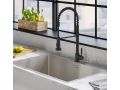 Elegant black kitchen faucet with a professional, industrial-style design, paired with a modern stainless steel sink in a bright kitchen setting, featuring a marble countertop and a window overlooking an urban landscape