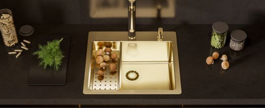 Fregadero de cocina dorado Alveus combinado con un grifo de cocina negro y dorado en una cocina completamente negra, junto con un grifo de cocina negro y dorado